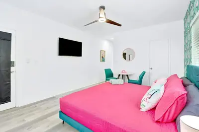 a bedroom with a pink bed and a ceiling fan at Modern Miami Beach Studio with King Bed in Miami Beach