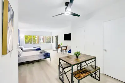 a living room with a bed and a table at Bright 1BR Miami Beach Stay Near the Ocean in Miami Beach