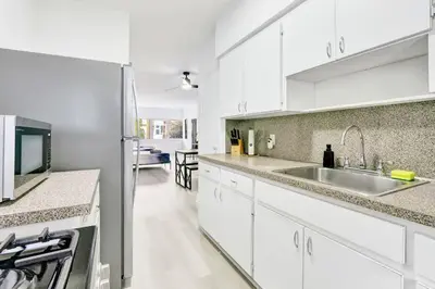 a white kitchen with a sink and a refrigerator at Bright 1BR Miami Beach Stay Near the Ocean in Miami Beach