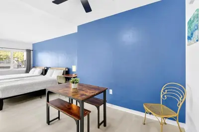a bedroom with a bed and a table and chairs at Sunny Miami Beach Studio with 2 Queens plus Workspace in Miami Beach