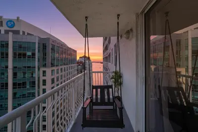 a balcony with a view of the sunset on a building at Sky-High Luxury 3BR with Stunning Brickell City & Bay Views in Miami