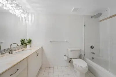 a white bathroom with a toilet and a tub and a sink at Sky-High Luxury 3BR with Stunning Brickell City & Bay Views in Miami