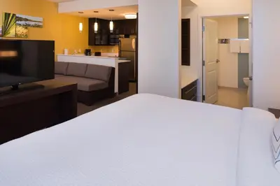 a bedroom with a white bed and a living room at Residence Inn by Marriott Miami West/FL Turnpike in Miami