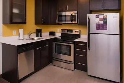 a kitchen with stainless steel appliances and wooden cabinets at Residence Inn by Marriott Miami West/FL Turnpike in Miami