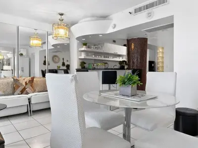 a dining room with a table and white chairs at Miami Beach Studio with shared Heated Pool & Gym in Miami Beach