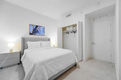 a white bedroom with a white bed and a door at Modern Escape in Brickell w Pool & Gym in Miami