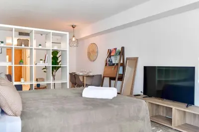 a living room with a bed and a flat screen tv at Studio W Panoramic Views Prime Comfort in Miami