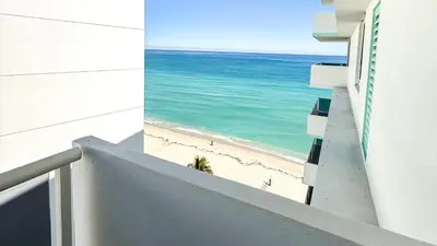 a view of the beach from the balcony of a building at Great 2BR Condo-DIRECT BEACH ACCESS Pool, Gym and FREE Parking in Hollywood