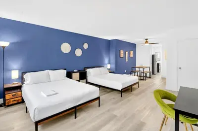 a room with two beds and a blue wall at Cozy Miami Beach Studio with 2 Queens plus Workspace in Miami Beach