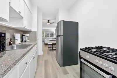 a kitchen with a stainless steel refrigerator next to a stove at Cozy Miami Beach Studio with 2 Queens plus Workspace in Miami Beach