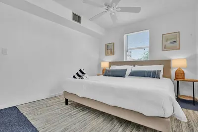 a white bedroom with a bed and a ceiling fan at Oceanfront Residence by Atlantikos in Hollywood