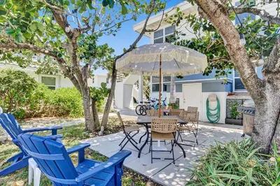 a patio with blue chairs and a table with an umbrella at Oceanfront Residence by Atlantikos in Hollywood