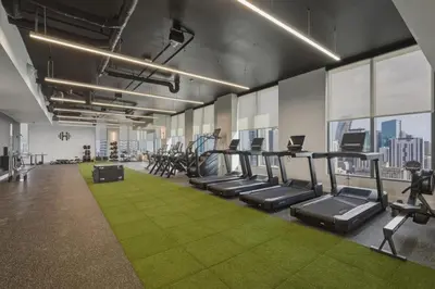 a gym with rows of tread machines and green carpet at New Luxury Studio Downtown Miami Prime Location in Miami