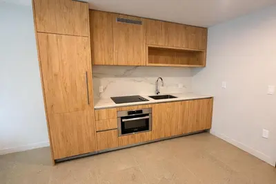 a kitchen with wooden cabinets and a sink at Lujoso apartamento ,The Crosby Miami World Center in Miami