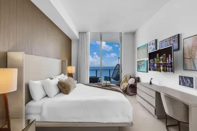 a bedroom with a large white bed and a desk at Lyfe Resort Ocean View Gym Direct Beach Access in Hollywood