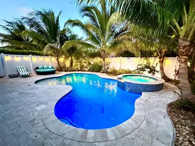 a swimming pool in a backyard with palm trees at Private Luxe Pool Club Heated Spa in Fort Lauderdale