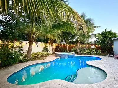 a swimming pool in a yard with palm trees at Private Luxe Pool Club Heated Spa in Fort Lauderdale