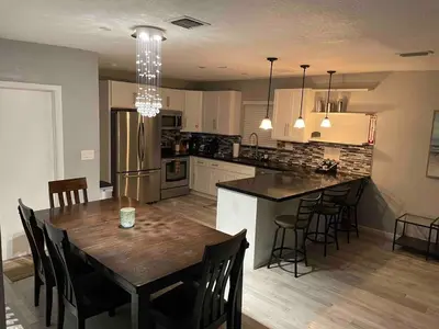 a kitchen with a wooden table and a dining room at Private Luxe Pool Club Heated Spa in Fort Lauderdale