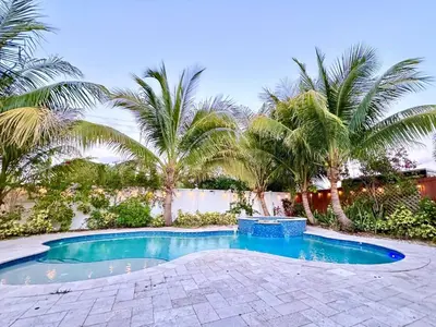 a swimming pool in a yard with palm trees at Private Luxe Pool Club Heated Spa in Fort Lauderdale
