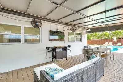 a patio with couches and a table and a table and a pool at 3 Mi to Sea! Family Pool House in Fort Lauderdale in Fort Lauderdale
