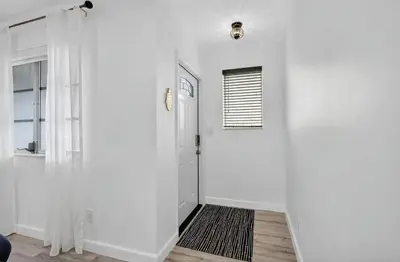 a hallway with white walls and a white door at Spacious 3BR Home with Private Pool in Hollywood in Hollywood