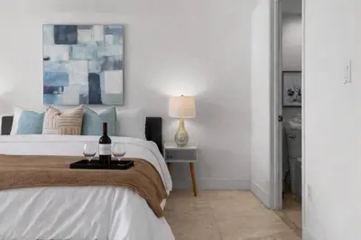 a bedroom with a bed with a bottle and two wine glasses at The Palazzo, Heart of Miami, Rooftop Pool, Lux Spa in Miami