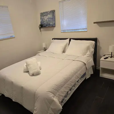 a large white bed with white sheets and pillows at Cozy private 2BR Home with Outdoor space and BBQ grill in Hollywood