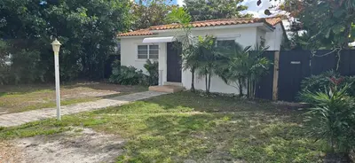 a small white house with a gate and a fence at Cozy private 2BR Home with Outdoor space and BBQ grill in Hollywood