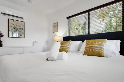 a bedroom with a white bed with yellow pillows at Walnut Beach - By Atlantikos in Hollywood