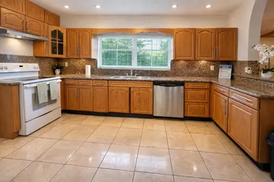 a kitchen with wooden cabinets and white appliances at Cassa Wynwood in Miami