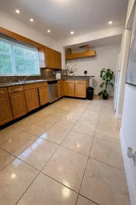 a large kitchen with wooden cabinets and a tile floor at Cassa Wynwood in Miami
