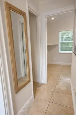 a hallway with a mirror and a tiled floor at Cassa Wynwood in Miami