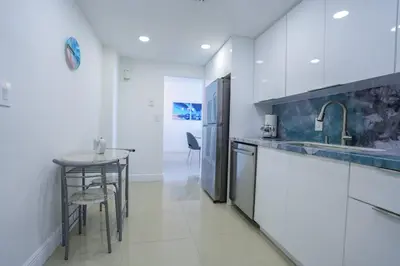 a kitchen with a counter and a table and a refrigerator at The Tides on Hollywood Beach in Hollywood