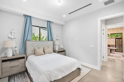 a white bedroom with a bed and blue curtains at New construction Fort Lauderdale luxury villa with Pool in Fort Lauderdale