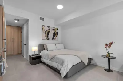 a white bedroom with a bed and a table at Brand New Modern Downtown Studio at Prime Location in Miami
