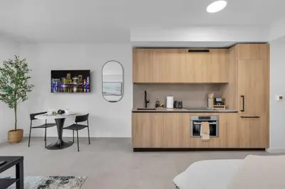 a kitchen with wooden cabinets and a table in a room at Brand New Modern Downtown Studio at Prime Location in Miami
