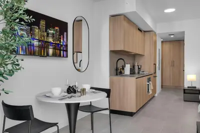 a kitchen and living room with a table and chairs at Brand New Modern Downtown Studio at Prime Location in Miami