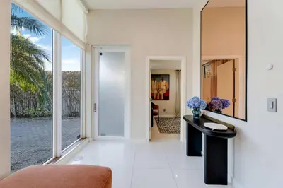 a living room with a large window and a table at Casa Anton- Artist Home Pool & Rooftop Hot Tub in Miami