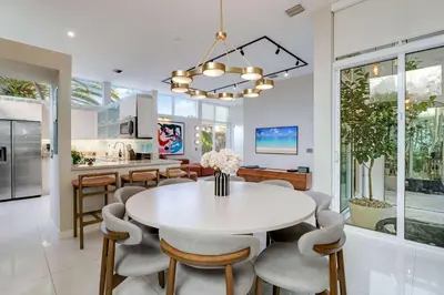 a kitchen and dining room with a white table and chairs at Casa Anton- Artist Home Pool & Rooftop Hot Tub in Miami