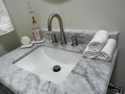 a bathroom sink with a white marble counter top at Spring Village by the Canal Loft in Miami