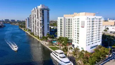 a boat in a river next to tall buildings at Intracoastal Oasis in Fort Lauderdale