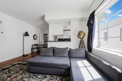 a living room with a couch and a large window at Alton Apts By At Mine Hospitality in Miami Beach