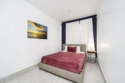 a bedroom with a bed with a red blanket at Drexel Apts By At Mine Hospitality in Miami Beach