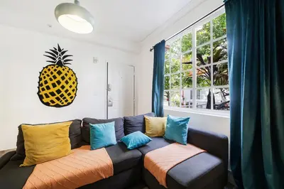 a living room with a couch with colorful pillows at Drexel Apts By At Mine Hospitality in Miami Beach