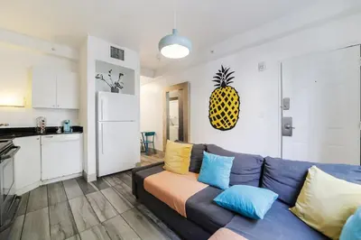 a living room with a blue couch with colorful pillows at Drexel Apts By At Mine Hospitality in Miami Beach