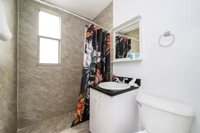 a bathroom with a toilet and a sink at Drexel Apts By At Mine Hospitality in Miami Beach
