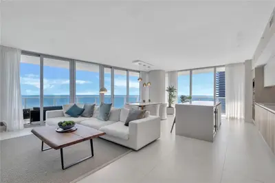 a living room with a white couch and a table at Prime Oceanfront 3BR Mansion in the Sky in Hollywood