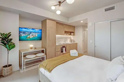 a bedroom with a large bed and a kitchen at Modern MIA Worldcenter Studio with Balcony Pool & Gym in Miami