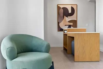a green chair and a desk in a room at The Crosby Miami Worldcenter Downtown Miami in Miami