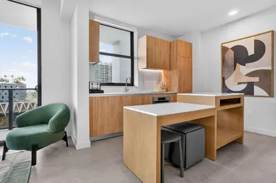 a kitchen with a desk and a green chair at The Crosby Miami Worldcenter Downtown Miami in Miami